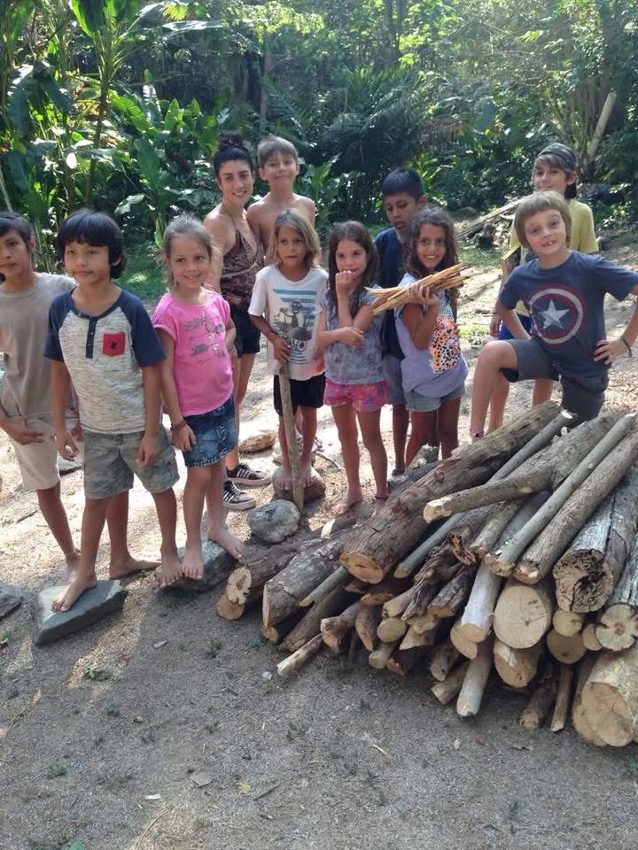 Niños junto a una pila de leña en el rancho