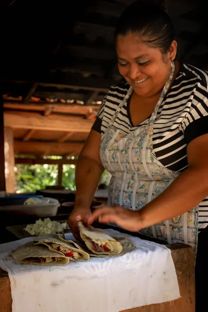 Cocinera preparando quesadillas en la palapa
