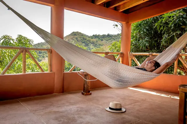 Descansando en una hamaca en la terraza de la cabaña, con vista al cerro